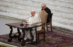 Pope Francis speaks at an audience with nuns and religious superiors in the Paul VI Hall at The Vatican, Thursday, May 5, 2022. Francis, 85, was wheeled to the audience after he has been suffering from strained ligaments in his right knee for several months. He revealed he recently received some injections to try to relieve the pain. (AP Photo/Alessandra Tarantino)